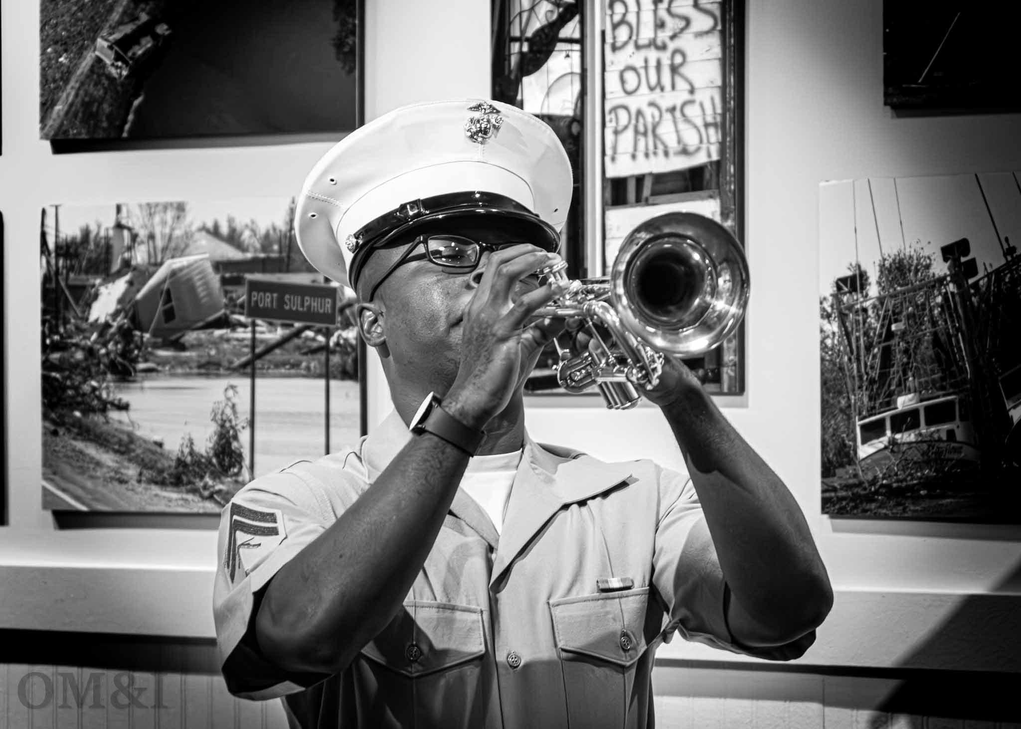 Black-and-white portrait of a uniformed trumpet player performing indoors