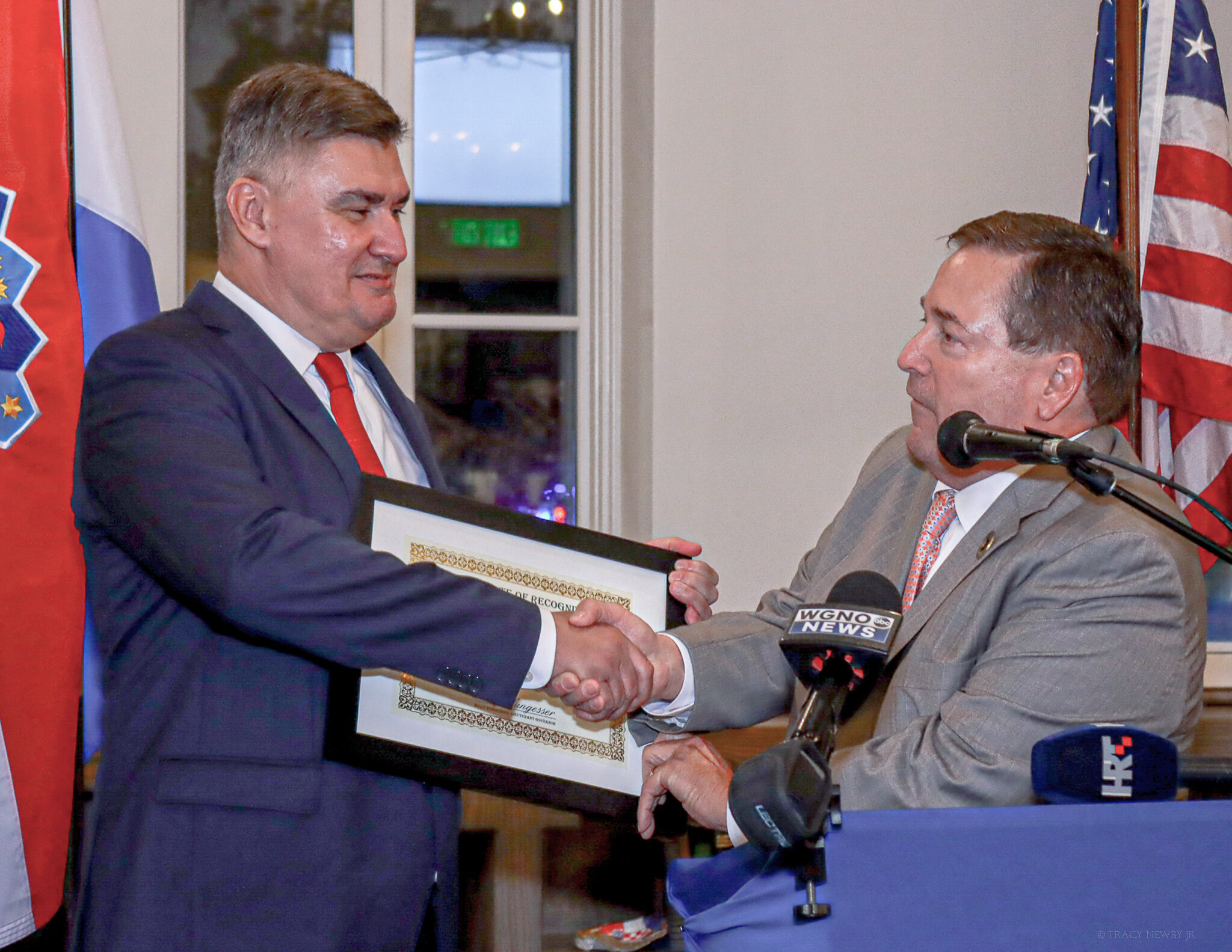 The president of Croatia and Louisiana Lieutenant Governor Billy Nungesser exchange a certificate at a formal civic event