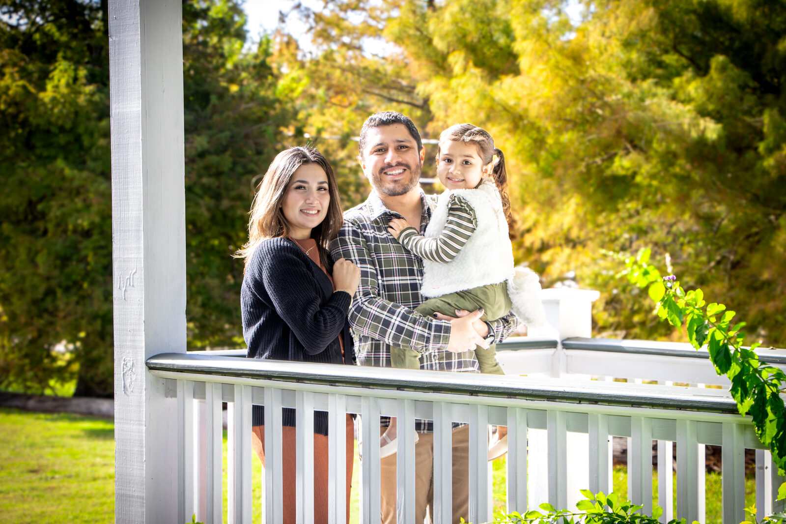 A young family photographed together in warm evening light
